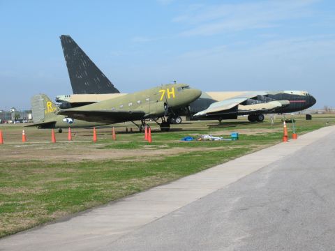 1997 Ford Crown Victoria - A pair of vintage aircraft sit on a grassy field under a clear blue sky.