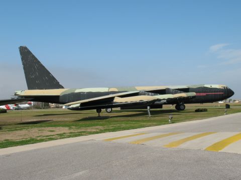 1997 Ford Crown Victoria - Large bomber aircraft parked on a grassy field next to a runway, with another plane in the distance.