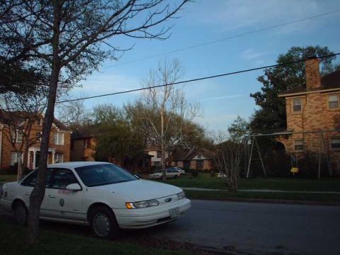 1996 Ford Taurus - A white 1996 Ford Taurus sedan is parked on the side of a residential street.