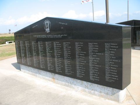 1997 Ford Crown Victoria - A large black granite memorial wall lists names of fallen soldiers, with flags flying in the background.