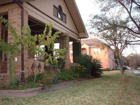 1996 Ford Taurus - A residential street scene features a house with a covered porch and surrounding greenery.