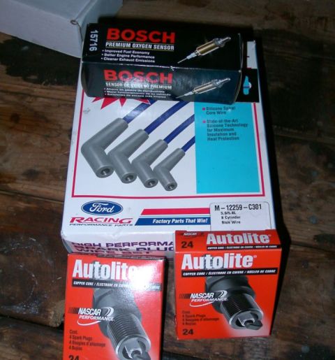 1994 Ford Bronco - A collection of automotive tune-up parts including spark plugs, wires, and oxygen sensors.