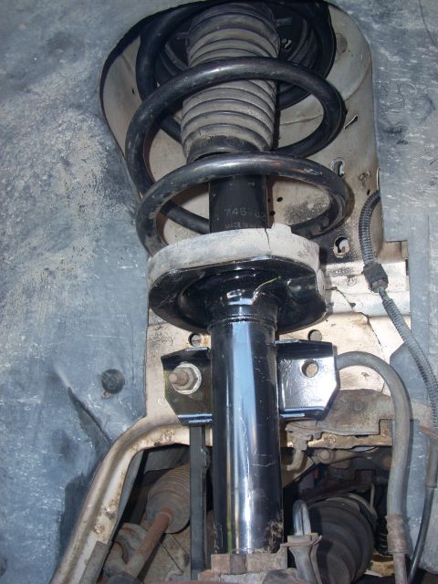 1991 Ford Taurus - Close-up of a front suspension strut and coil spring assembly, showing part number 74S-03.