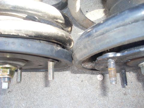 1991 Ford Taurus - A close-up view of two vehicle suspension springs and their mounting hardware.