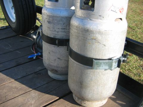 1992 Ford Mustang - Propane tanks are strapped to a trailer, with a spare tire nearby.