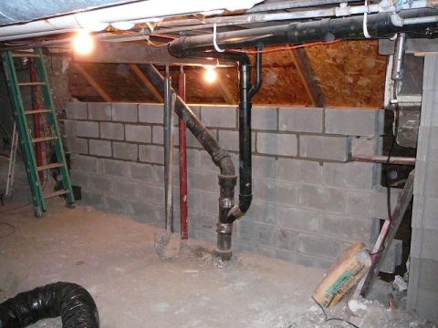 1997 Mercury Grand Marquis - Basement construction shows cinder block wall, plumbing, and lighting fixtures.