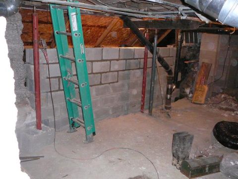 1997 Mercury Grand Marquis - A basement area shows ongoing construction with a new cinder block wall and various plumbing and structural elements.