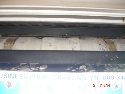 1979 Ford Bronco - Close-up view of an exhaust pipe and a license plate with partial text visible.