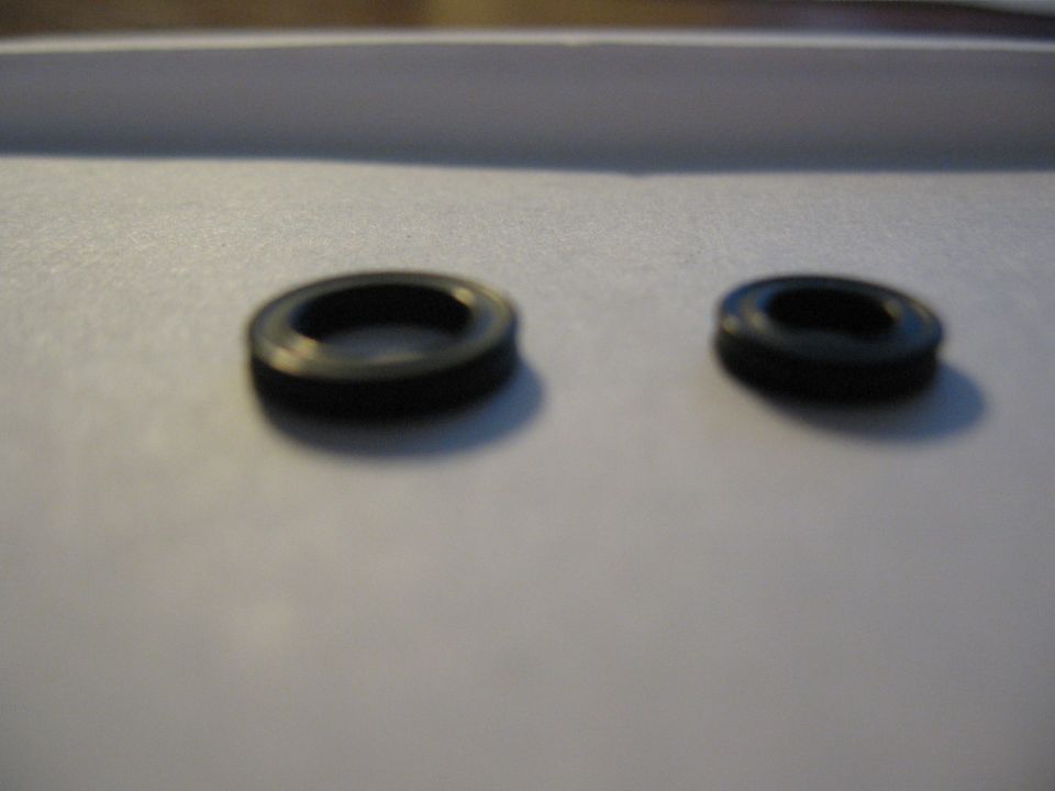 Two black O-rings on a light gray surface