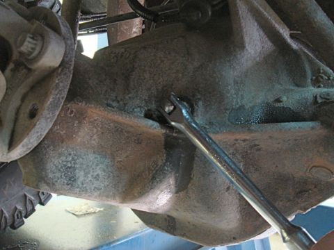 1996 Ford Bronco - Differential housing plug being serviced with a wrench.