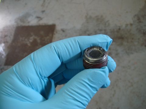 1996 Ford Bronco - Drain plug removed during fluid change, showing metal debris.