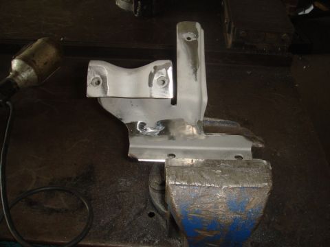 1996 Ford Bronco - A metal bracket is secured in a vise, possibly for repair or modification.