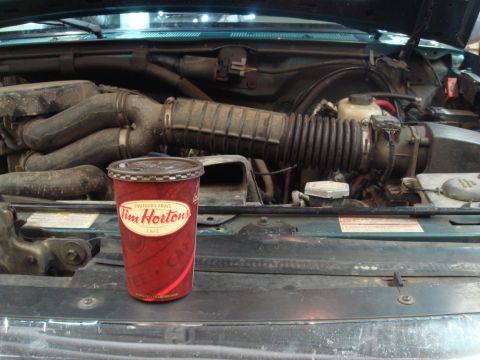 1996 Ford Bronco - A Tim Hortons cup sits in the engine bay of a vehicle.