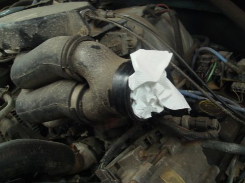 1996 Ford Bronco - Close-up of a 1996 Ford Bronco engine bay, showing an intake tube with a paper towel inserted.