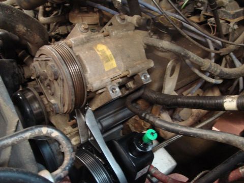 1996 Ford Bronco - Close-up view of engine components including the AC compressor and power steering pump.
