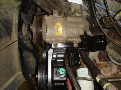 1996 Ford Bronco - Engine bay detail showing AC compressor and power steering pump assembly.