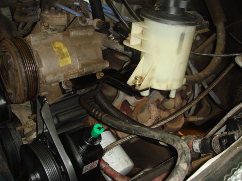 1996 Ford Bronco - This image shows various engine components, including the power steering pump and AC compressor, in a vehicle's engine bay.