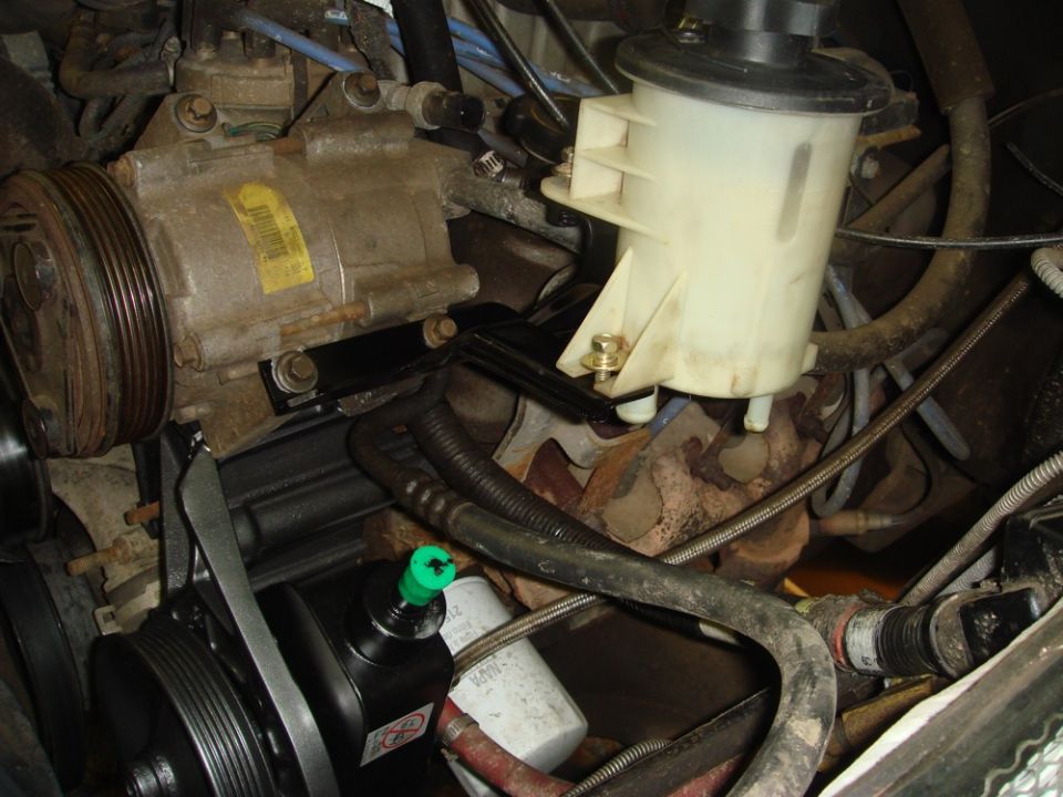 Close-up of engine parts including power steering pump and AC compressor