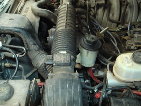 1996 Ford Bronco - Close-up of an engine bay, focusing on the air intake system and fluid reservoirs.