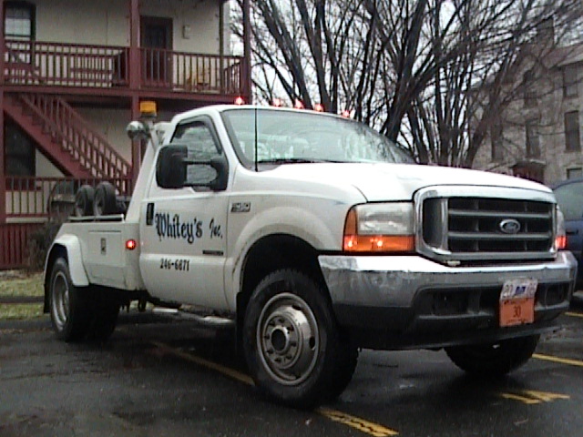 White tow truck with "Whitey's Inc." lettering and phone number