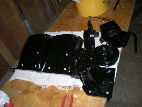 1993 Ford Bronco - Various black painted suspension parts are laid out on a workbench, suggesting a restoration or upgrade project.