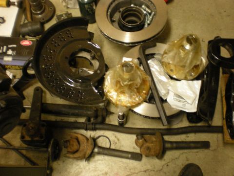 1993 Ford Bronco - Collection of automotive parts, likely for a suspension or brake system upgrade, laid out on a concrete floor.