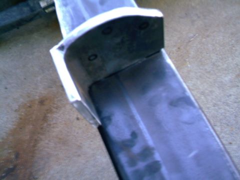 1989 Ford Bronco - Close-up of a vehicle's rear bumper section, showing mounting points and a metallic surface.