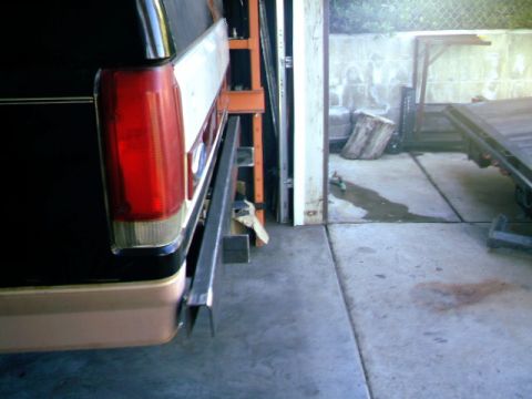 1989 Ford Bronco - The rear of a vehicle, possibly a Ford Bronco from the 1980s, is visible with a custom metal bumper extension.
