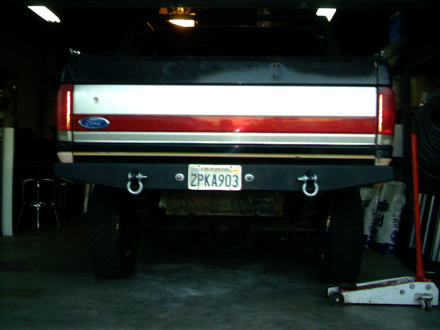 1989 Ford Bronco rear view showing a custom black bumper with D-rings and a California license plate reading 2PKA903