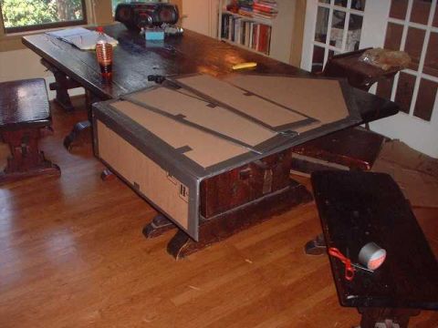 1996 Ford Taurus - A large cardboard box is placed on a wooden table in a room with hardwood floors.