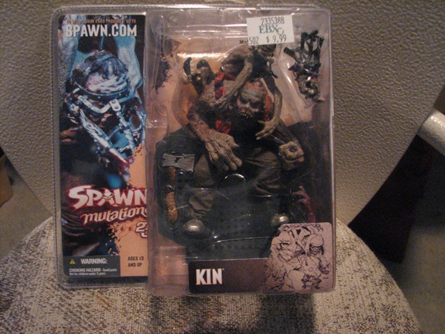 Two Spawn action figures in plastic packaging. One is labeled 'KIN'