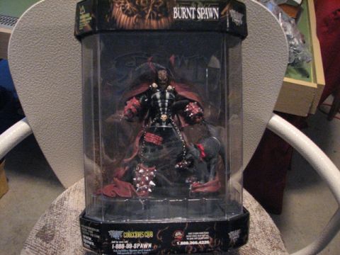 1991 Ford Bronco - A "Burnt Spawn" action figure is displayed in its packaging on a chair.