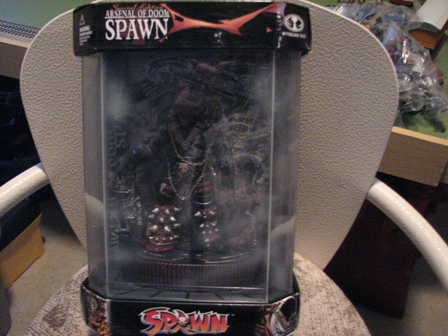 Spawn action figure in clear plastic packaging with "Arsenal of Doom Spawn" text