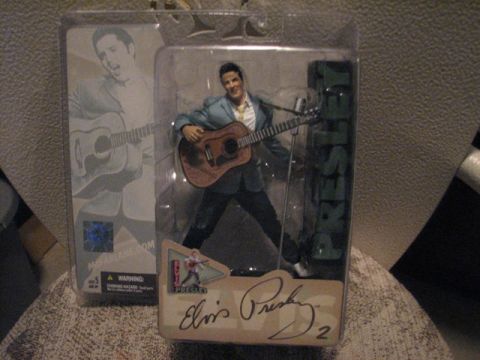 1991 Ford Bronco - An Elvis Presley action figure is displayed in its original packaging, complete with a guitar and signature.