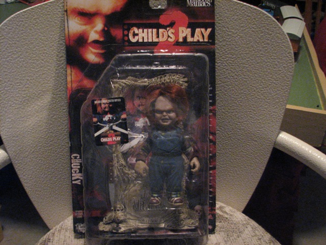 Child's Play 2 Chucky doll in plastic packaging, with a cardboard backing showing the character's face