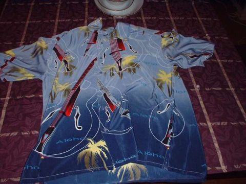 1996 Ford Taurus - A blue Hawaiian shirt with a guitar and palm tree pattern is laid out on a bed.