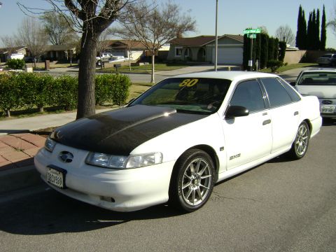 1991 Ford Taurus - This 1991 Ford Taurus features a carbon fiber hood and aftermarket wheels, giving it a custom look.