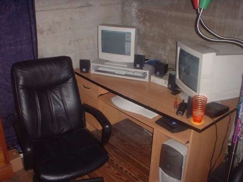 1996 Ford Taurus - A home office setup features a desk with dual computer monitors, a keyboard, speakers, and a black leather office chair.