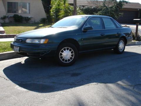 1991 Ford Taurus - This 1991 Ford Taurus sedan is captured in a three-quarter front view, parked on a residential street.