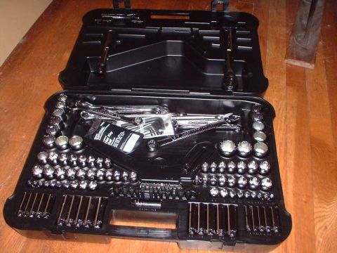 1996 Ford Taurus - A comprehensive tool kit is displayed open, a variety of sockets and wrenches within its organized compartments.
