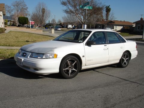 1991 Ford Taurus - White 1991 Ford Taurus sedan parked on a residential street.