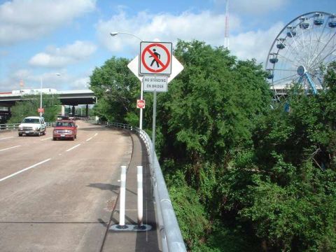 1996 Ford Taurus - A red car travels on a bridge, with a Ferris wheel visible in the distance under a cloudy sky.