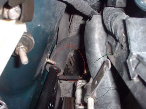1996 Ford Taurus - A close-up view of various hoses and mechanical parts within a vehicle's engine compartment.