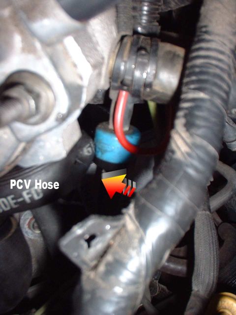 1996 Ford Taurus - Close-up view of a PCV hose and associated engine components, with an arrow pointing to a connection.