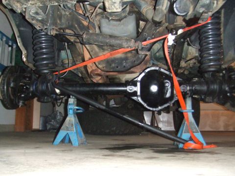 1996 Ford Bronco - Undercarriage view of a 1996 Ford Bronco, supported by jack stands during work.