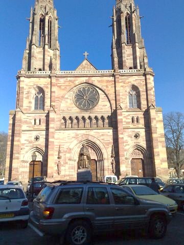 1991 Ford Crown Victoria - Several vehicles are parked in front of a large, ornate church under a clear blue sky.