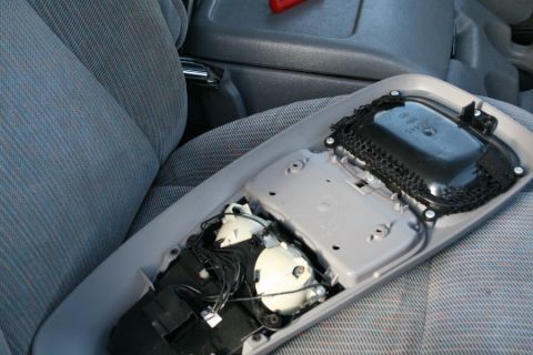 1996 Ford Bronco - The interior overhead console of a vehicle is shown disassembled, revealing its internal wiring and components.