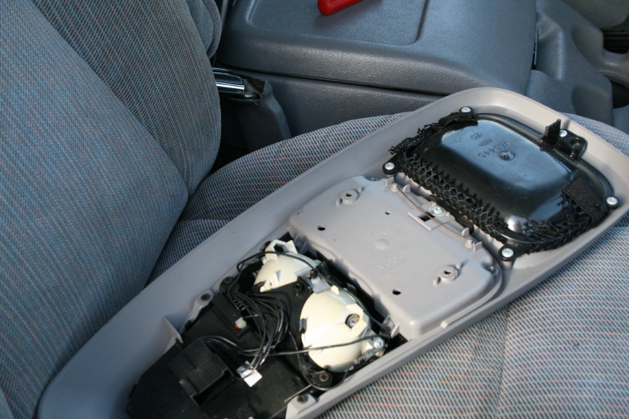 Overhead console disassembled, showing wiring and internal components. Gray patterned seats visible