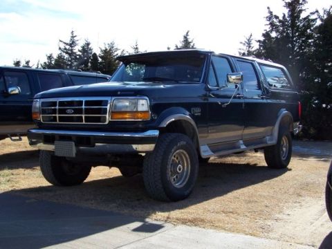 1995 Ford C-350 (Centurion Conversions) - Dark blue 1995 Ford C-350 (Centurion Conversions) SUV with chrome trim and aftermarket visor.