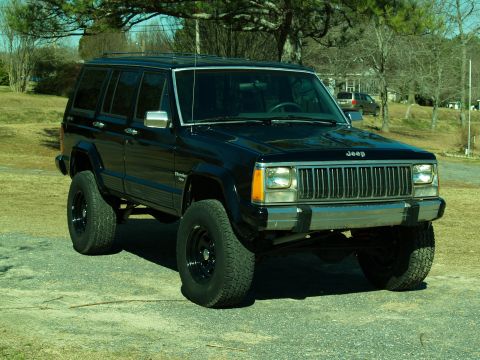 1989 Jeep Cherokee - Lifted black 1989 Jeep Cherokee with aftermarket wheels and tires.